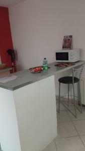 a kitchen with a counter with a microwave and a stool at Colombine in Vénissieux