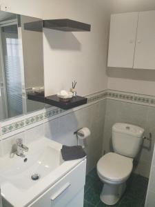 a bathroom with a white toilet and a sink at Colombine in Vénissieux +4 photos