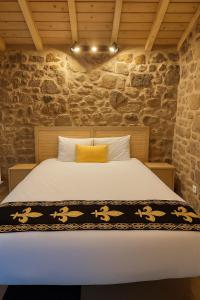 a bed in a room with a stone wall at Uíma River House 