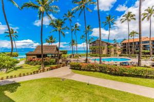 an image of a resort with a swimming pool and palm trees at Papakea Resort E203 in Honokowai