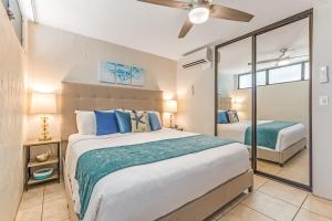 a bedroom with a large bed and a mirror at Papakea Resort E203 in Honokowai +29 photos