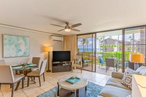 a living room with a couch and a tv at Papakea Resort E203 in Honokowai