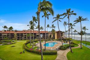 an aerial view of a resort with a pool and palm trees at Papakea Resort E203 in Honokowai