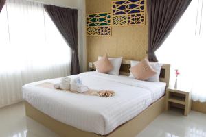 a bedroom with a bed with white sheets and pillows at Crystal Nongkhai Hotel in Nong Khai