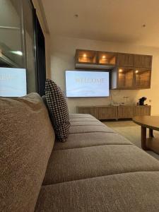 达布阿扎Appartement moderne avec vue mer & piscine, Dar Bouazza的带沙发和电视的客厅 更多3张照片