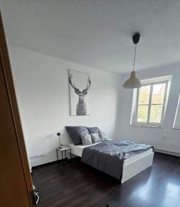 ein Schlafzimmer mit einem Bett und einem Hirschbild an der Wand in der Unterkunft 3-Raum-Wohnung beim Luther in Chemnitz