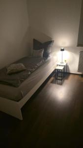 Bett in einem Zimmer mit einer Lampe und einem Tisch in der Unterkunft 3-Raum-Wohnung beim Luther in Chemnitz