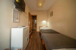 a room with two beds and a small refrigerator at GK Pansion in Kruševac