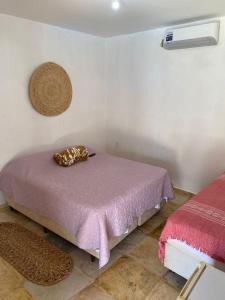a bedroom with a bed with a purple blanket at Brisa Mansa in Barra Grande +14 photos