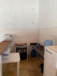 a small kitchen with a stove and a sink at Brisa Mansa in Barra Grande