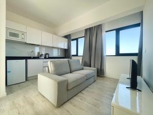 een woonkamer met een bank en een keuken bij Apartamento T1 - MedSal Residence in Santa Maria +6 foto's