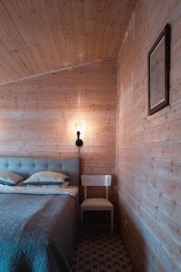 a bedroom with a bed and a chair in it at Kanali Guest House - Sauna Included - Free Parking in Pärnu