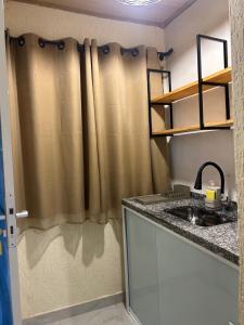 eine Küche mit einem Waschbecken und einem Duschvorhang in der Unterkunft Suite Tarituba 1 in Paraty