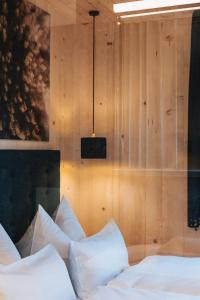 Un dormitorio con almohadas blancas sobre una cama. en tinnes apartments, en Schoppernau