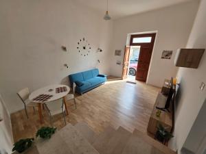 een woonkamer met een blauwe bank en een tafel bij Greta Guest House in Iglesias