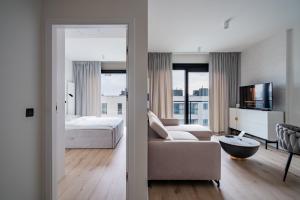 a bedroom with a bed and a living room with a couch at Towarowa Towers SkyLine View in Warsaw