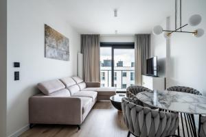 a living room with a couch and a table at Towarowa Towers SkyLine View in Warsaw