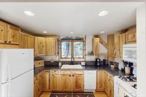 FlorissantにあるTimberframe Treehouseの木製のキャビネットと白い冷蔵庫を備えたキッチン