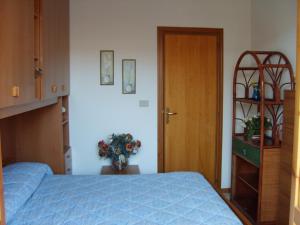 - une chambre avec un lit bleu et une porte en bois dans l'établissement Casa Vacanze Trinacria, à Riposto