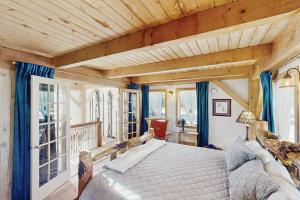 FlorissantにあるTimberframe Treehouseのベッドルーム1室(青いカーテン付きの大型ベッド1台付)
