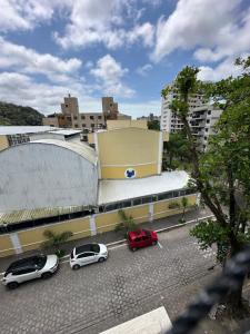 a group of cars parked in front of a building at Apartamento com Hidromassagem próximo a praia da enseada in Guarujá