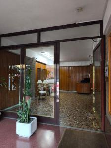 a lobby with glass doors and a potted plant at Libertador 6 MVD in Montevideo