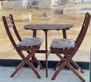 a wooden table and two chairs next to a window at Apartamento T1 - MedSal Residence in Santa Maria +7 photos