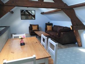 a living room with a table and a couch at Au 112, maison d'hôtes meublée in Estrées-Saint-Denis