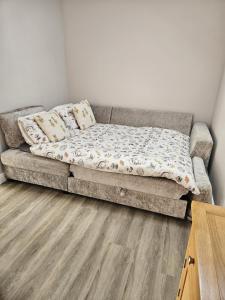 a couch in a living room with a wooden floor at The Woottons Barn with Hot Tub in Croxden