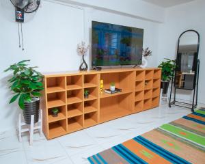 Stylish Studio, Pool and Walk to Beach في واتامو: غرفة معيشة مع تلفزيون على مركز ترفيهي خشبي