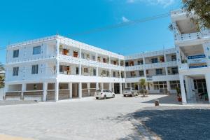 Stylish Studio, Pool and Walk to Beach في واتامو: مبنى أبيض فيه سيارة متوقفة أمامه