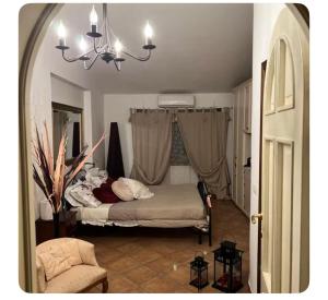 a bedroom with a bed and a chandelier at Casa Lucy in Ponte Buggianese