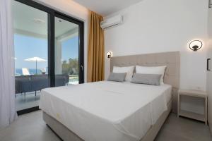 a bedroom with a large white bed and a balcony at Villa Marco in Zakynthos Town +139 photos