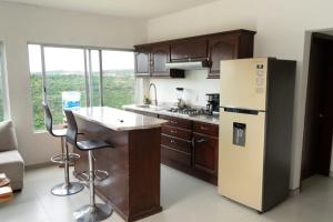 a kitchen with a refrigerator and a counter with stools at Terraza Lotelazo in Guadalajara