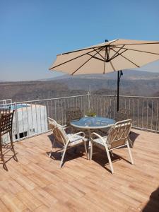 a patio with a table and chairs and an umbrella at Terraza Lotelazo in Guadalajara