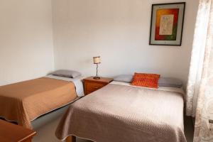 a room with two beds and a picture on the wall at Terraza Lotelazo in Guadalajara +15 photos