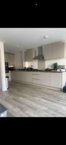 a large kitchen with white cabinets and a wooden floor at Brand new house oxford in Oxford