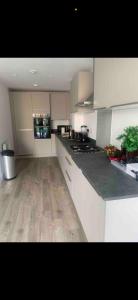 a kitchen with white cabinets and a wooden floor at Brand new house oxford in Oxford