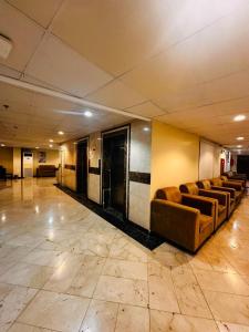 un vestíbulo con una fila de sofás en un edificio en Lualuat Ajyad Hotel, en La Meca