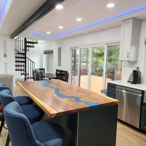 a kitchen with a wooden table and blue chairs at Unique 3-bed Lakefront Container Home in National City