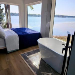 a bathroom with a tub and a bed and a large window at Unique 3-bed Lakefront Container Home in National City