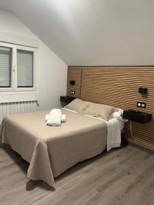 a bedroom with a large bed with a wooden headboard at Pensión Ferreiriño in Quiroga