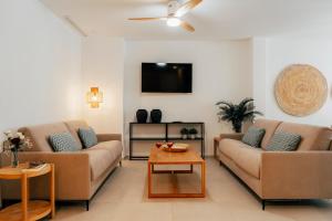 a living room with two couches and a tv at Valencia Living Suites in Picanya