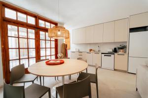 a kitchen with a wooden table and chairs at Valencia Living Suites in Picanya