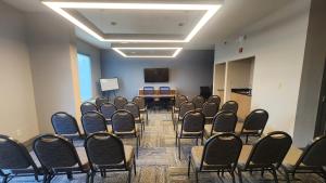 a conference room with chairs and a table and a screen at Holiday Inn Express Fredericksburg - Southpoint by IHG in Fredericksburg