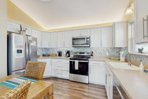 a kitchen with white cabinets and a stove top oven at The Lazy Bay in Rockport
