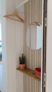 a mirror and a plant on a shelf in a room at L'Escale Songeonnaise in Songeons