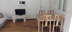 a dining room with a table and chairs and a television at villa tabaiba Rustic getaway in Las Lagunetas
