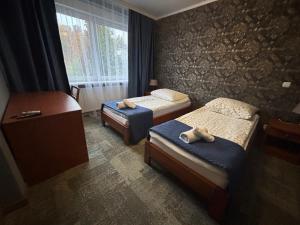 a bedroom with two beds with towels on them at Gościniec Witomino in Gdynia