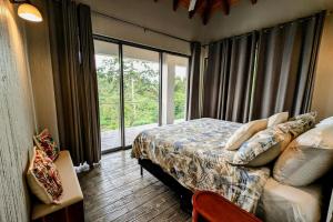 a bedroom with a bed and a large window at Cayo Casa Grande Modular Villa with Pool, Gym & Valley Views in Santa Elena +50 photos